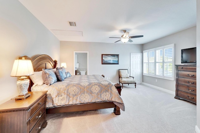 bedroom with baseboards, visible vents, a ceiling fan, light colored carpet, and ensuite bathroom