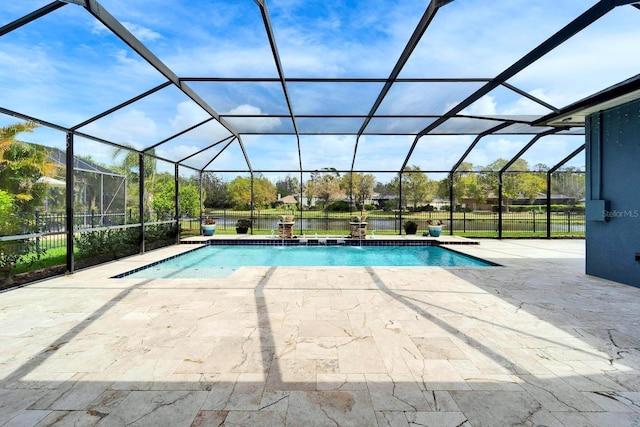 outdoor pool with glass enclosure, fence, and a patio