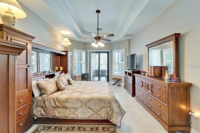 bedroom with light tile patterned flooring, a raised ceiling, visible vents, and baseboards