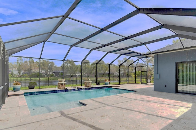 view of pool featuring glass enclosure and a patio