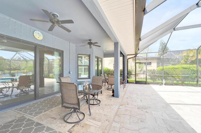 view of patio / terrace featuring ceiling fan, glass enclosure, and outdoor dining area