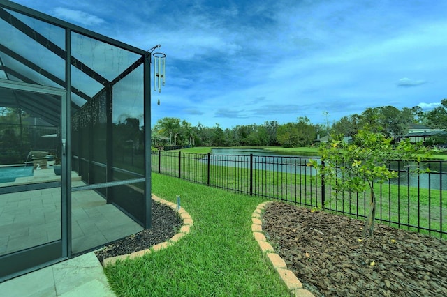 view of yard featuring glass enclosure, a fenced backyard, a water view, and a patio