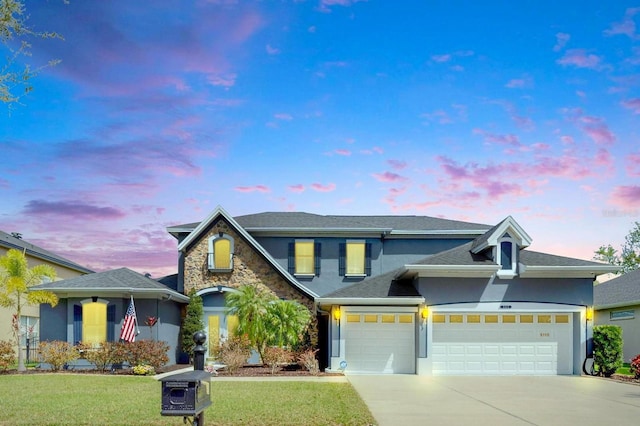 5115 Abisher Wood Ln, Brandon, FL 33511 - view of front facade with stucco siding, concrete driveway, a lawn, an attached garage, and stone siding