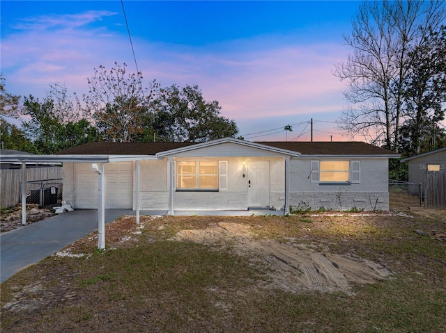 back of house at dusk featuring fence, driveway, and stucco siding