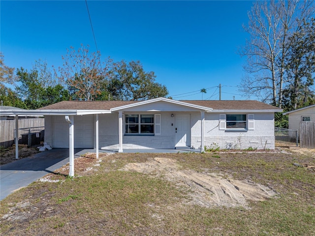 ranch-style house featuring driveway, an attached garage, and fence