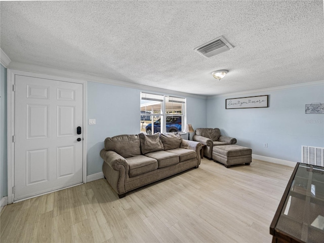 living room featuring ornamental molding, visible vents, and light wood finished floors