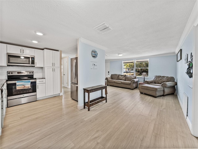 living area with baseboards, visible vents, light wood-style flooring, a textured ceiling, and crown molding