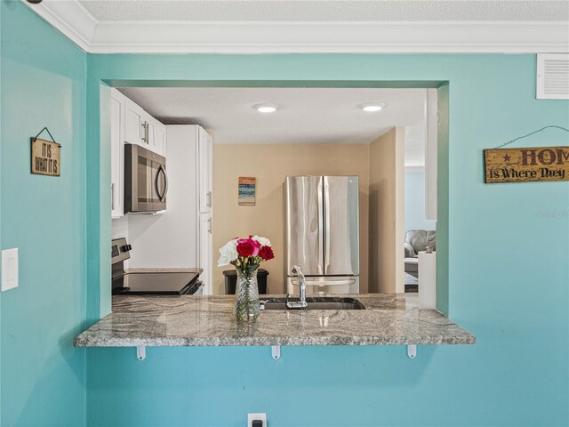 kitchen with stainless steel appliances, a breakfast bar, a sink, and a peninsula