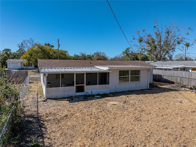 back of property featuring fence and a sunroom