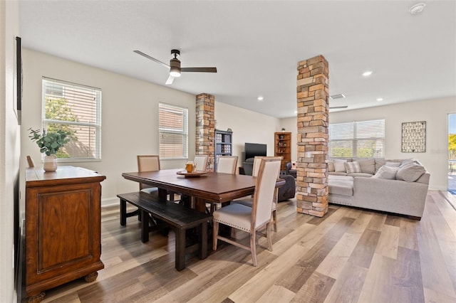 dining area featuring light wood-style floors, plenty of natural light, ornate columns, and ceiling fan