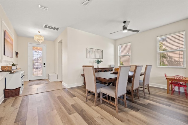 dining area featuring light wood finished floors, visible vents, and baseboards