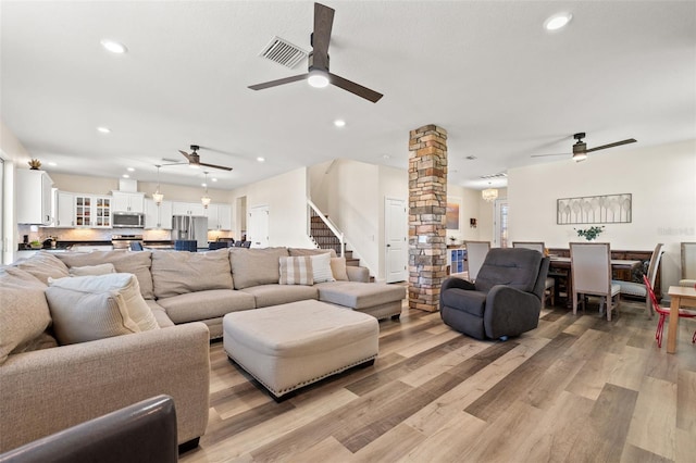 living area with recessed lighting, decorative columns, visible vents, and light wood-style floors