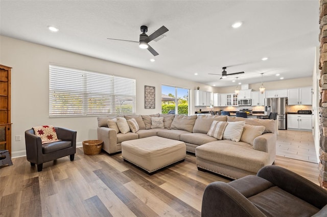 living area with ceiling fan, recessed lighting, and light wood-style floors