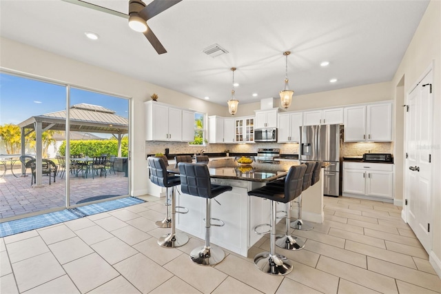 kitchen featuring tasteful backsplash, appliances with stainless steel finishes, visible vents, and white cabinets