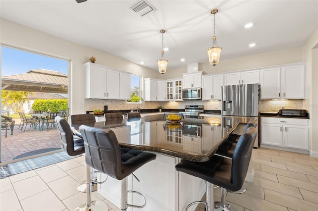 kitchen featuring light tile patterned floors, visible vents, white cabinetry, appliances with stainless steel finishes, and backsplash