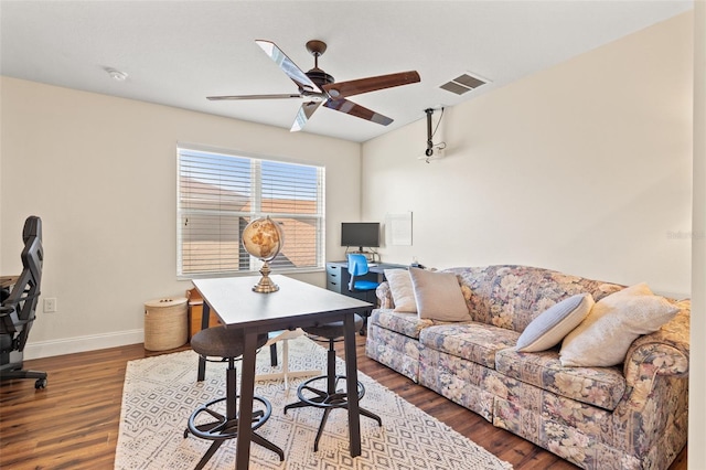 home office featuring a ceiling fan, baseboards, visible vents, and wood finished floors