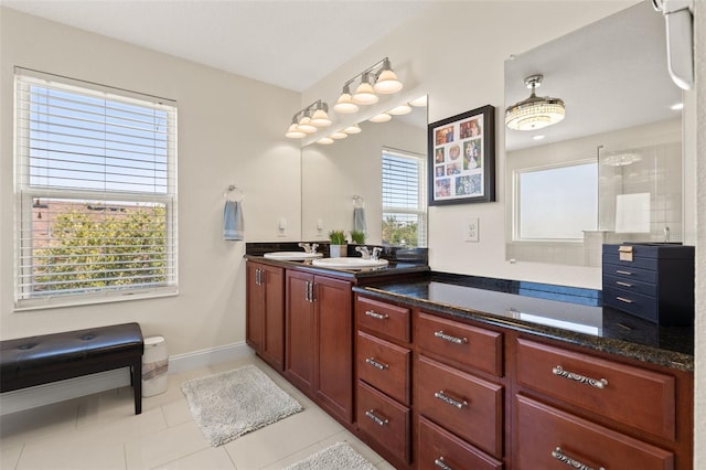 full bathroom featuring double vanity, tile patterned flooring, a sink, and baseboards