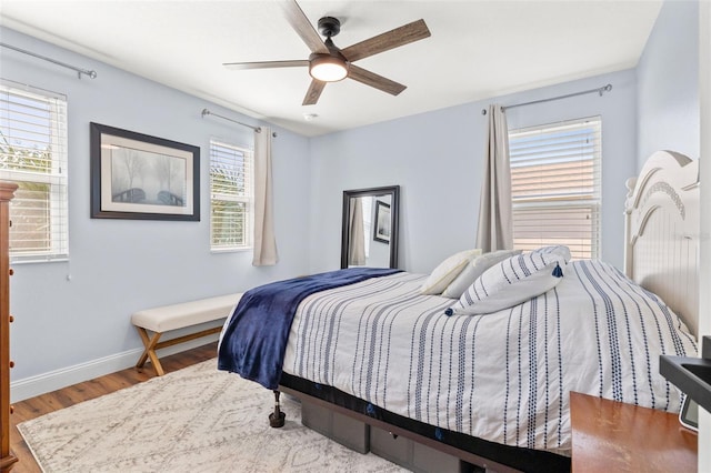 bedroom featuring a ceiling fan, baseboards, and wood finished floors