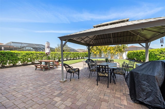 view of patio featuring a grill, outdoor dining area, and a gazebo