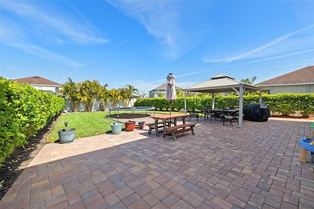 view of patio / terrace featuring a gazebo, a trampoline, and grilling area