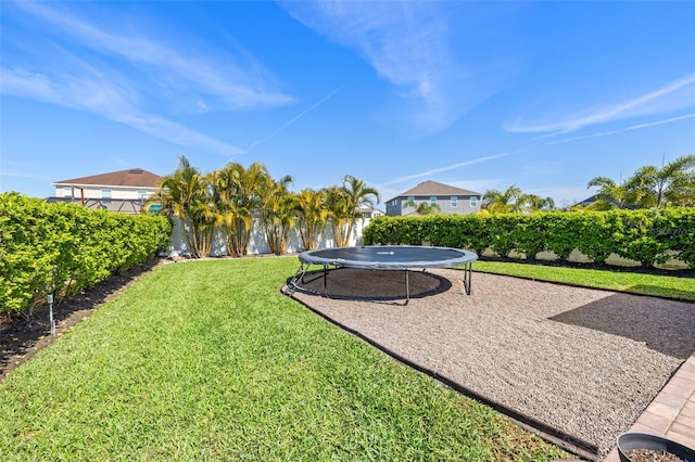 view of yard with a fenced backyard and a trampoline