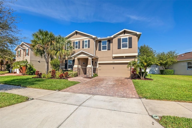 view of front facade featuring decorative driveway, stucco siding, an attached garage, stone siding, and a front lawn