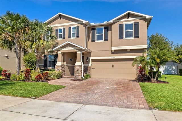 12225 Lake Blvd, New Port Richey, FL 34655 - view of front of home featuring decorative driveway, a front lawn, stucco siding, an attached garage, and stone siding