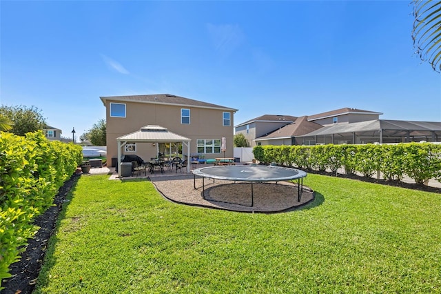 12225 Lake Blvd, New Port Richey, FL 34655 - back of house featuring a gazebo, stucco siding, a trampoline, and a patio