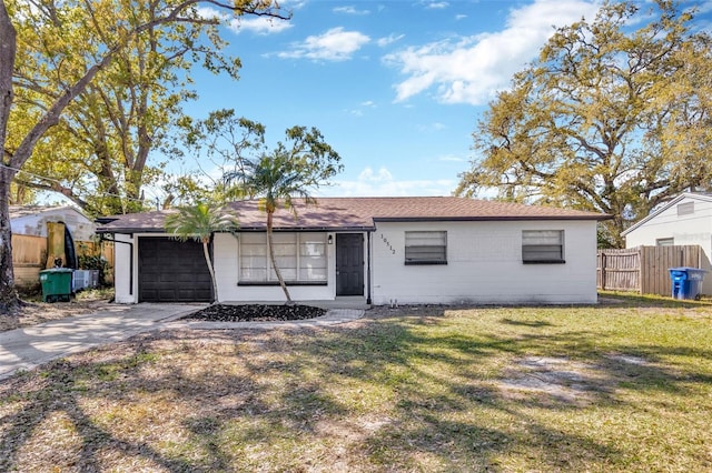 ranch-style home featuring a garage, a front yard, concrete driveway, and fence