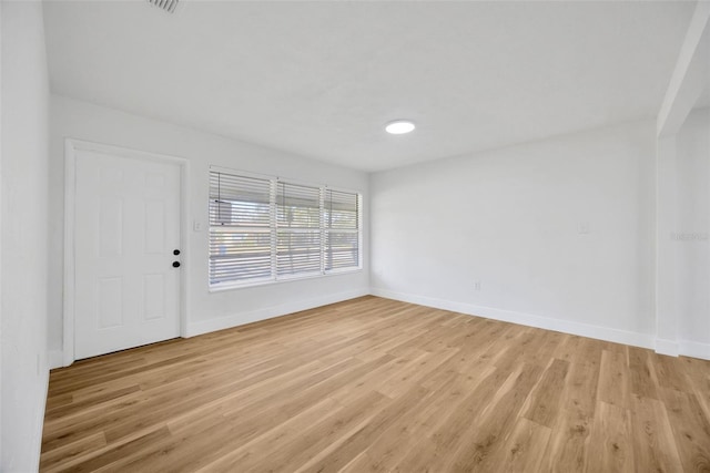 unfurnished room featuring light wood finished floors and baseboards