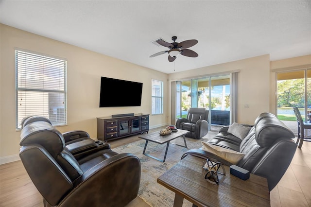 living area with visible vents, baseboards, and a ceiling fan