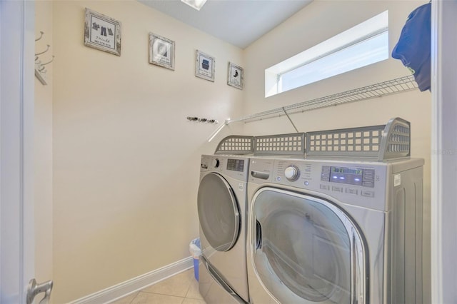 laundry room with laundry area, light tile patterned floors, baseboards, and independent washer and dryer