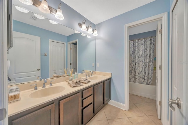 bathroom with a sink, visible vents, double vanity, and tile patterned flooring