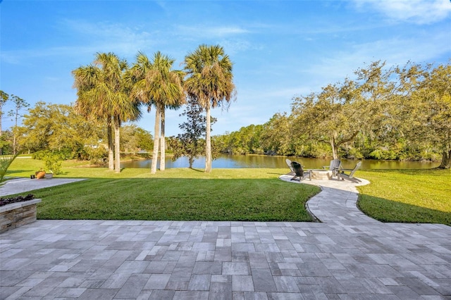 view of community with a water view, a lawn, an outdoor fire pit, and a patio area