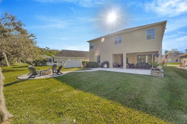 rear view of property with stucco siding, a lawn, fence, an outdoor living space with a fire pit, and a patio area