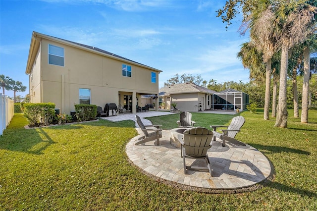 back of house with stucco siding, a fire pit, a lanai, a patio area, and a lawn