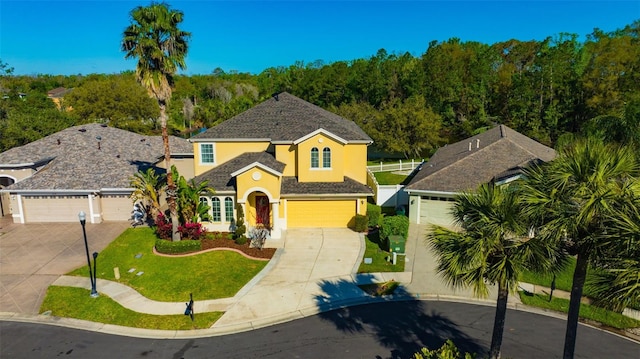 traditional home featuring stucco siding, concrete driveway, a front lawn, and fence