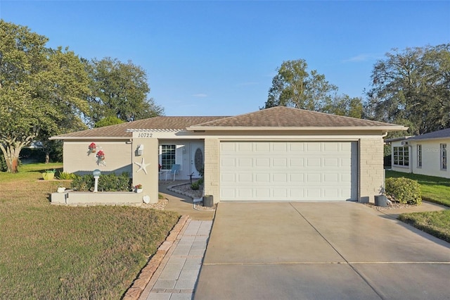 single story home featuring a garage, a front lawn, and concrete driveway