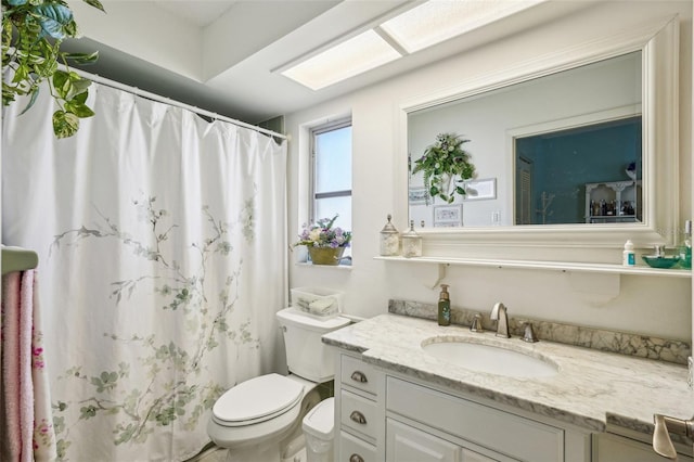 bathroom featuring curtained shower, vanity, and toilet