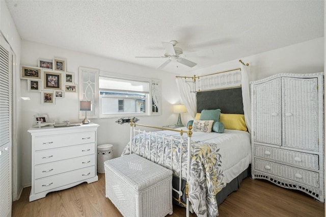 bedroom featuring ceiling fan, a textured ceiling, and wood finished floors