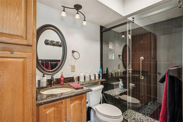 bathroom featuring a stall shower, vanity, and toilet