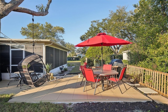 view of patio featuring a sunroom and outdoor dining area