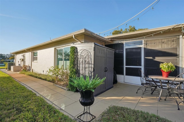 view of side of home featuring central AC unit, a patio area, and stucco siding