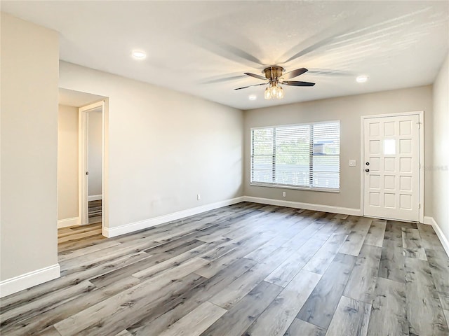 interior space featuring a ceiling fan, baseboards, and wood finished floors