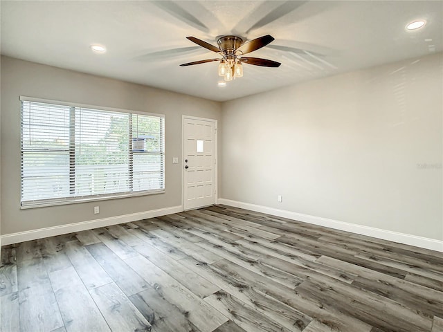 empty room with a ceiling fan, recessed lighting, baseboards, and wood finished floors