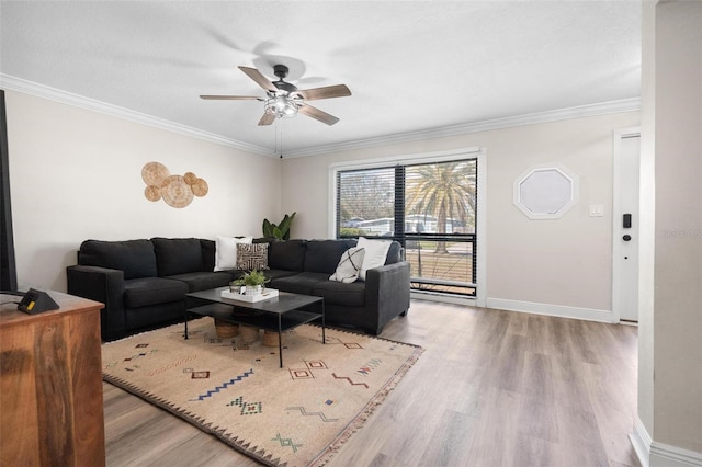 living area with ceiling fan, ornamental molding, wood finished floors, and baseboards