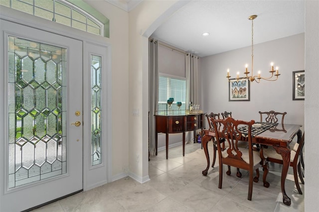 foyer entrance featuring baseboards, a chandelier, and arched walkways