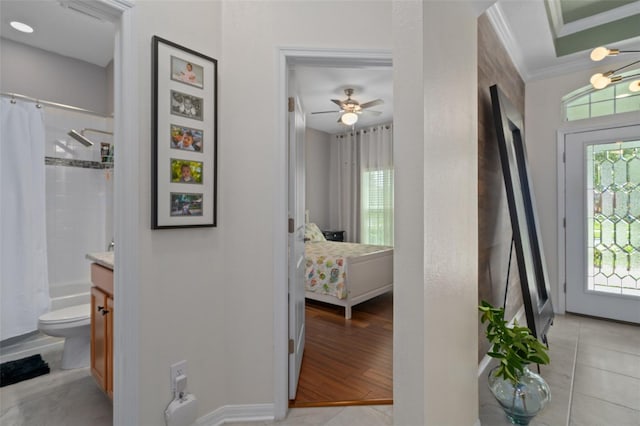 interior space featuring light tile patterned floors, baseboards, and crown molding