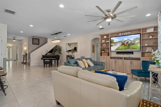 living area with a ceiling fan, arched walkways, visible vents, and recessed lighting