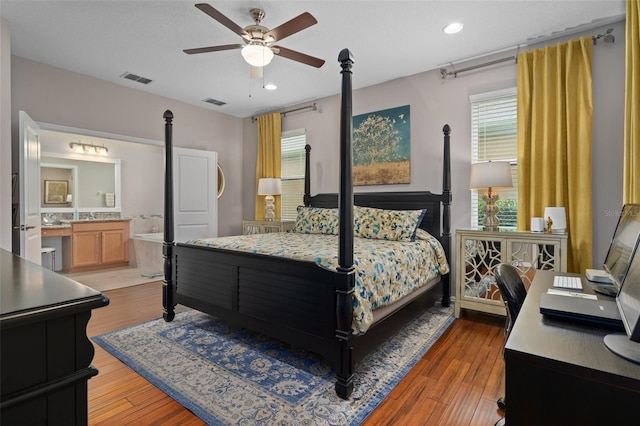 bedroom with recessed lighting, wood finished floors, visible vents, and connected bathroom